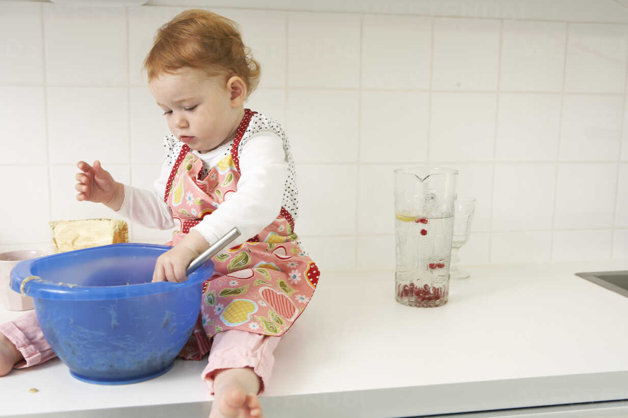 Little Girl Sitting On Kitchen Counter With Mixing Bowl Fsf Sandra Bielmeier Westend61