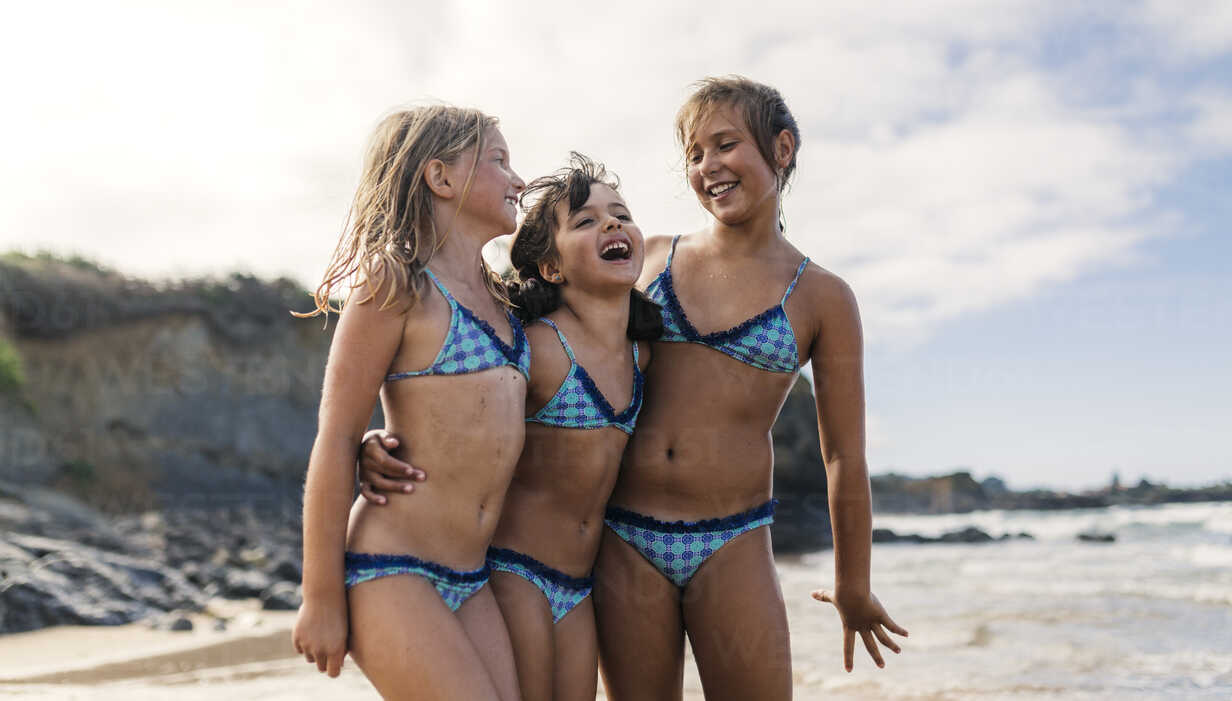 Spain Colunga Three Girls Standing Arm In Arm On The Beach Having Fun Stockphoto