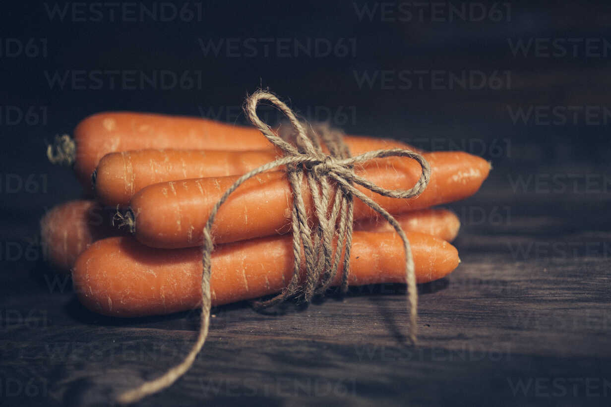 Bunch Of Five Carrots On Dark Wood Stockphoto