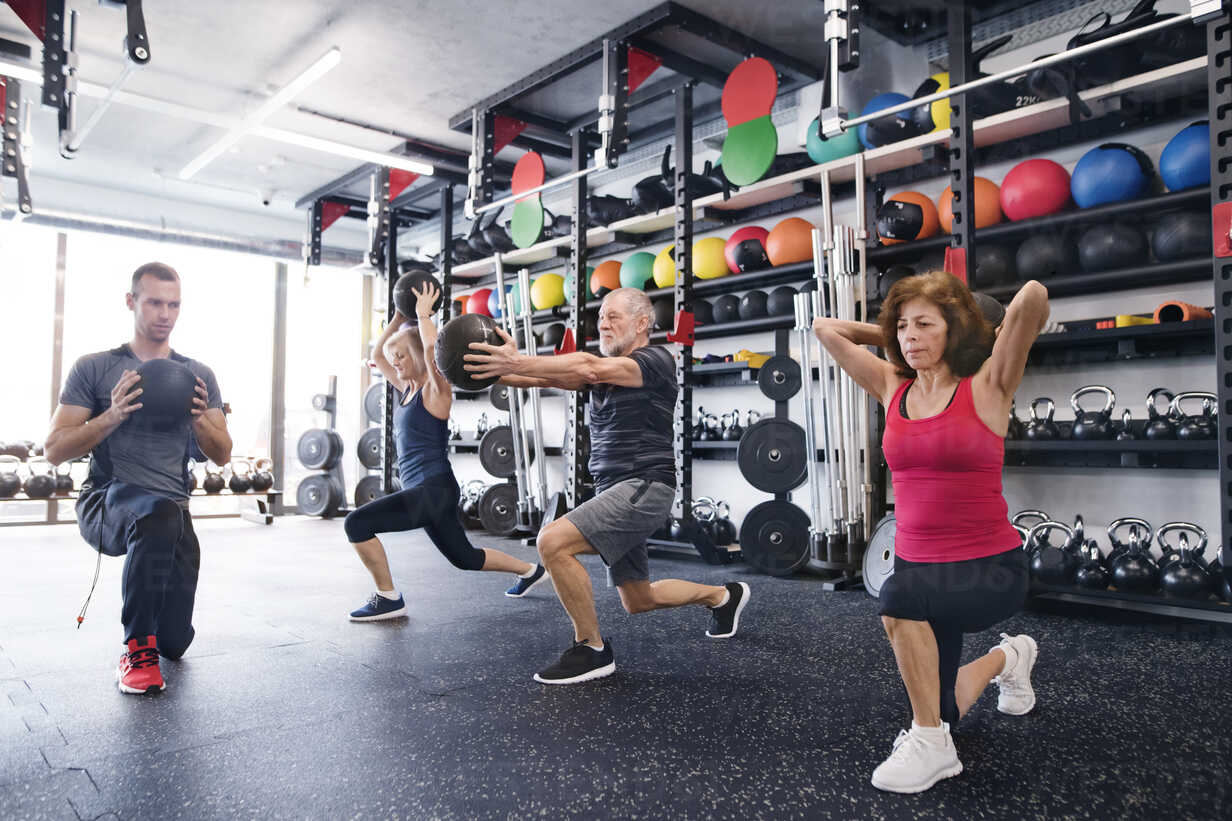 Group Of Fit Seniors With Personal Trainer In Gym Exercising With Medicine Balls Hapf Halfpoint Westend61