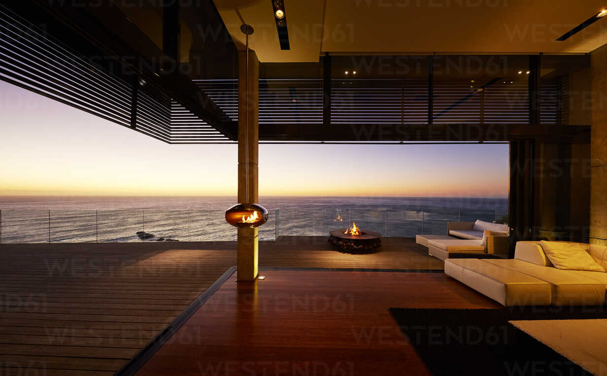 Fire Pit And Hanging Fireplace On Modern Luxury Patio With Sunset Ocean View Stockphoto