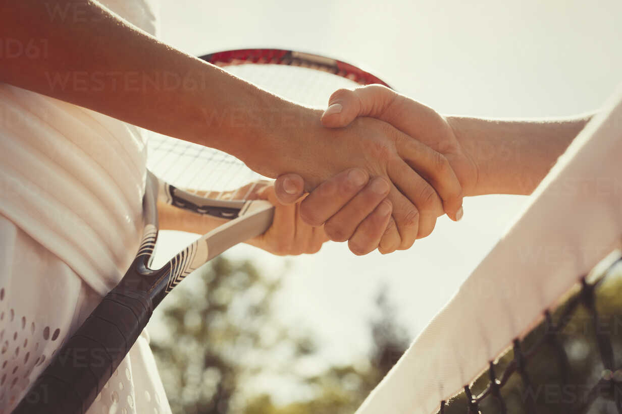 Close Up Tennis Players Handshaking In Sportsmanship At Net Stockphoto