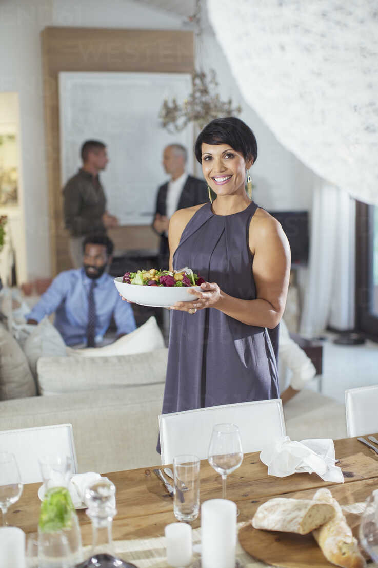 Woman Serving Food At Dinner Party Stockphoto