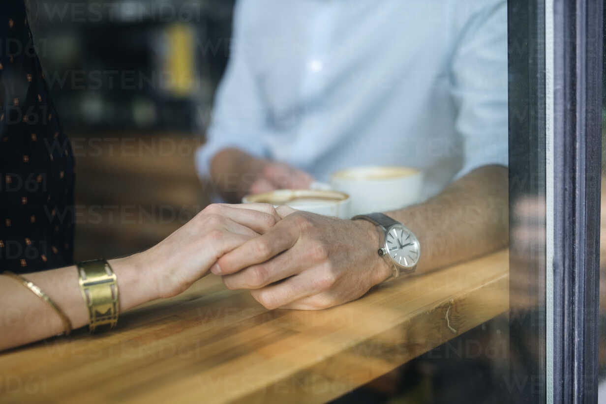Couple Holding Hands On Table Seen Through Window At Cafe Cavf Cavan Images Westend61