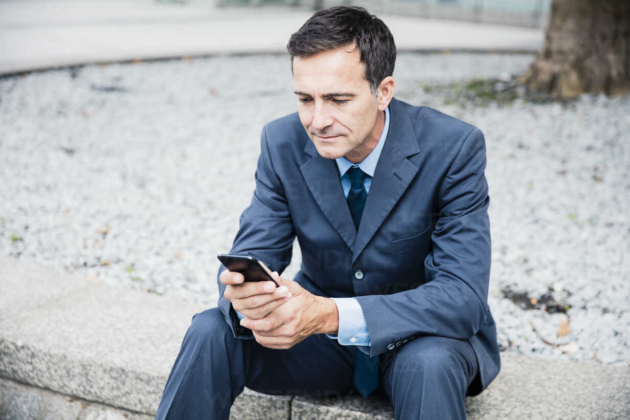 Businessman Sitting Down Using Cell Phone In The City Moef Robijn Page Westend61