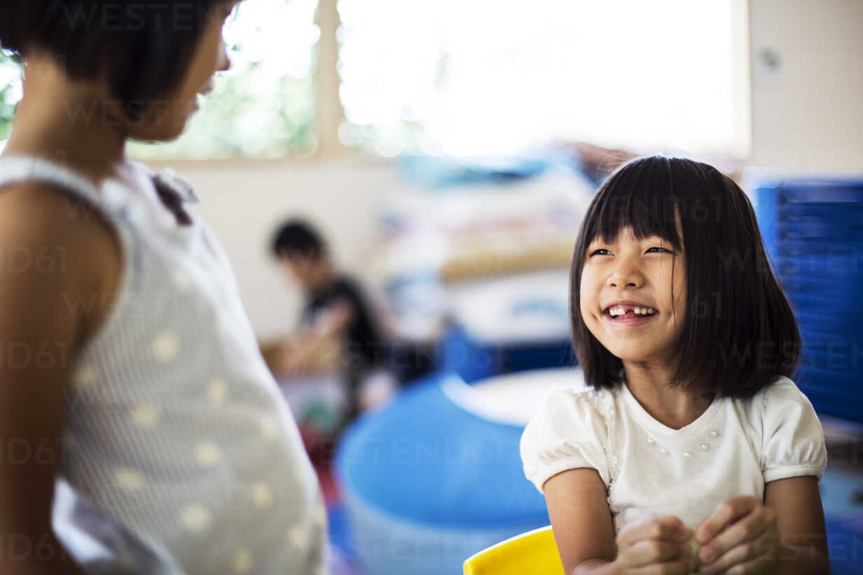 Two Smiling Girls In A Classroom In A Japanese Preschool