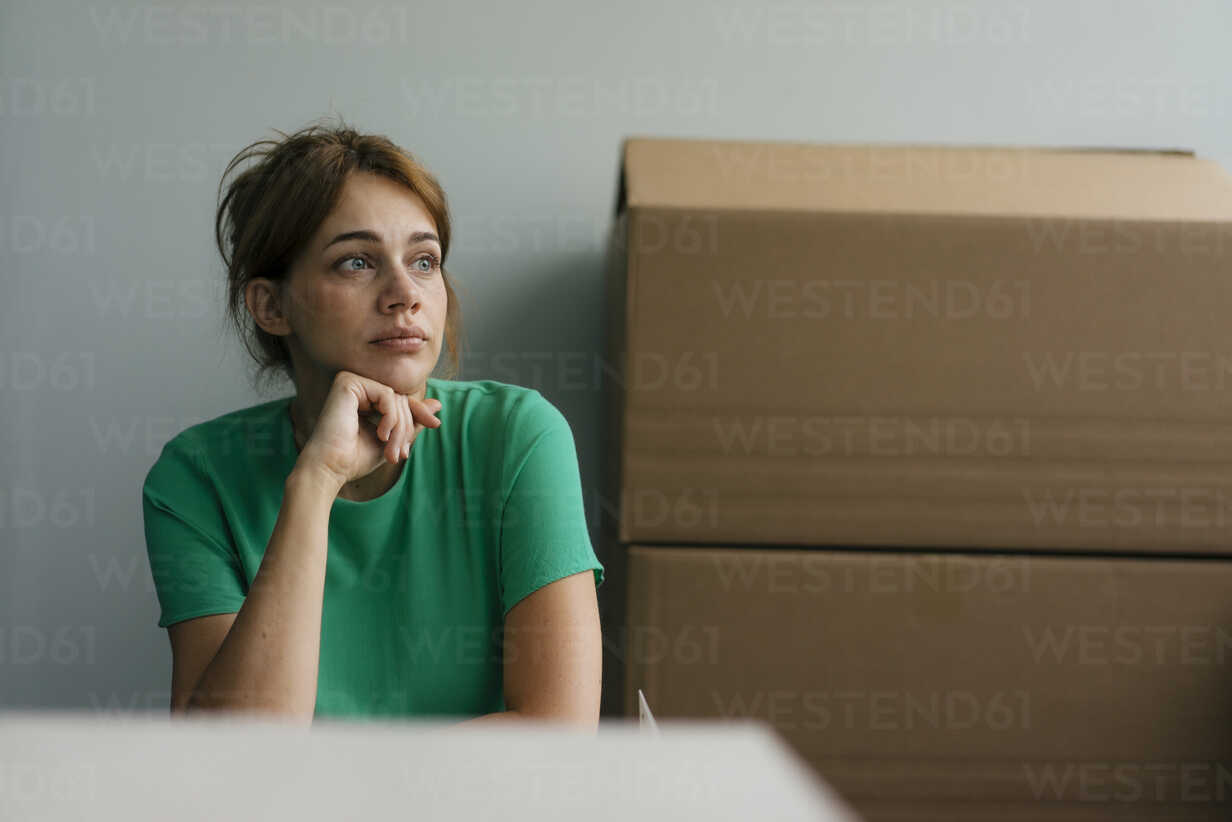 Thoughtful Woman Next To Cardboard Boxes In Office Knsf Kniel Synnatzschke Westend61