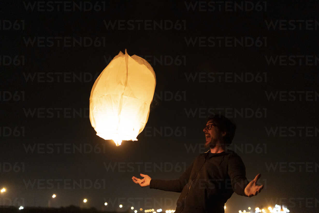 Excited Man With Floating Sky Lantern At Night Errf Eloisa Ramos Westend61