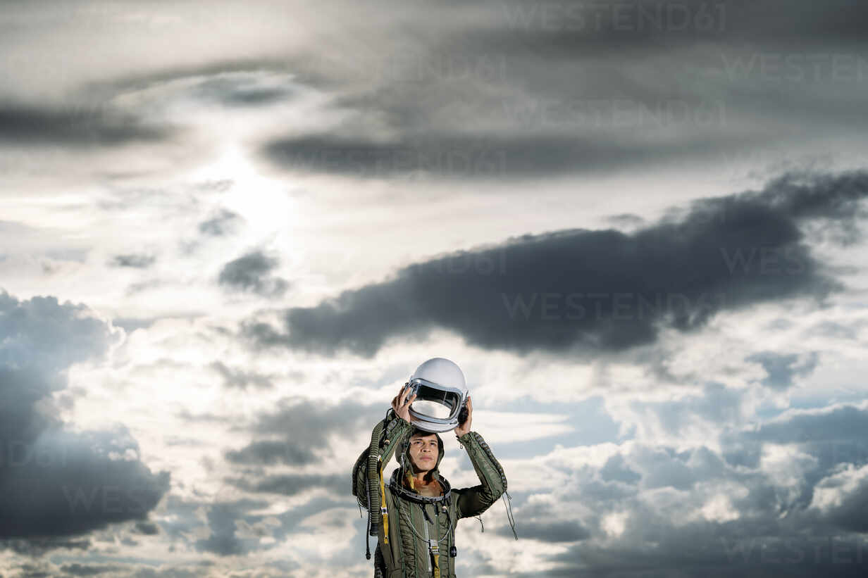 Man Posing Dressed As An Astronaut On A Meadow With Dramatic Clouds In The Background Damf