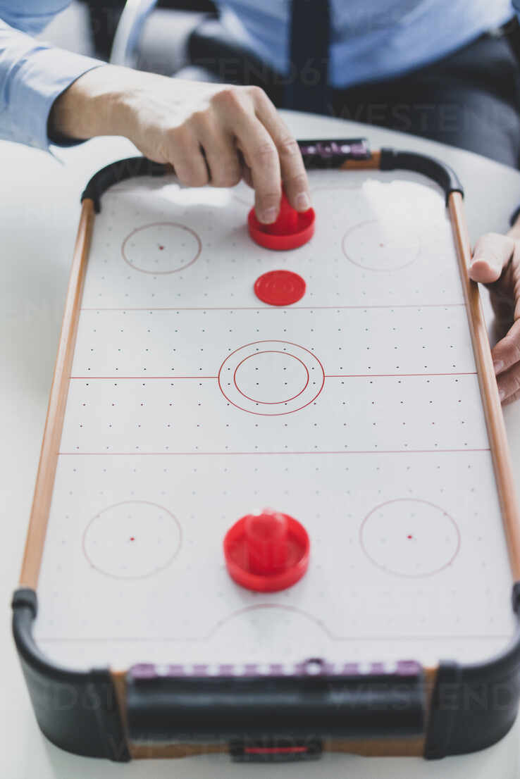 Close Up Of Businessman Playing Air Hockey Stockphoto