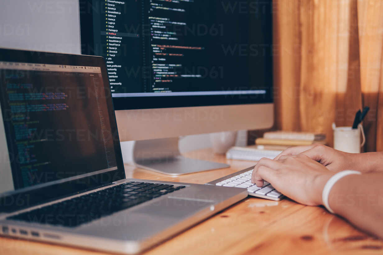 Cropped Image Of Computer Programmer Tying On Keyboard At Desk In Office Stockphoto