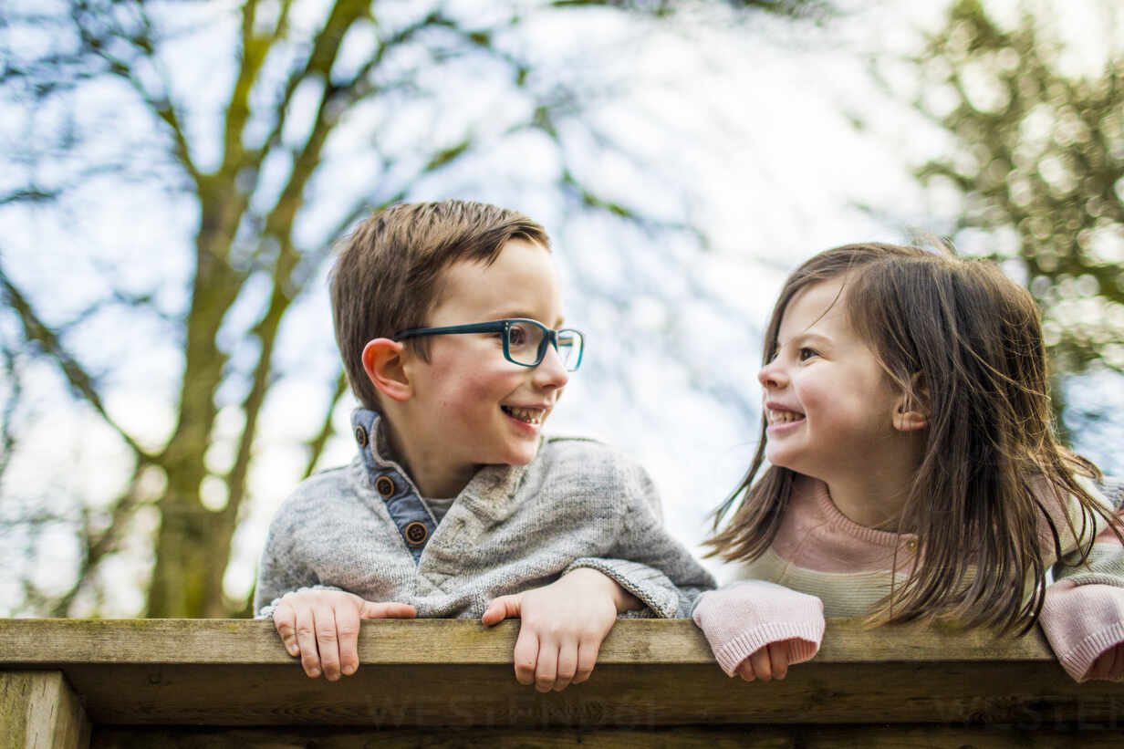 Playful Portrait Of Boy And Girl On Railing Stockphoto