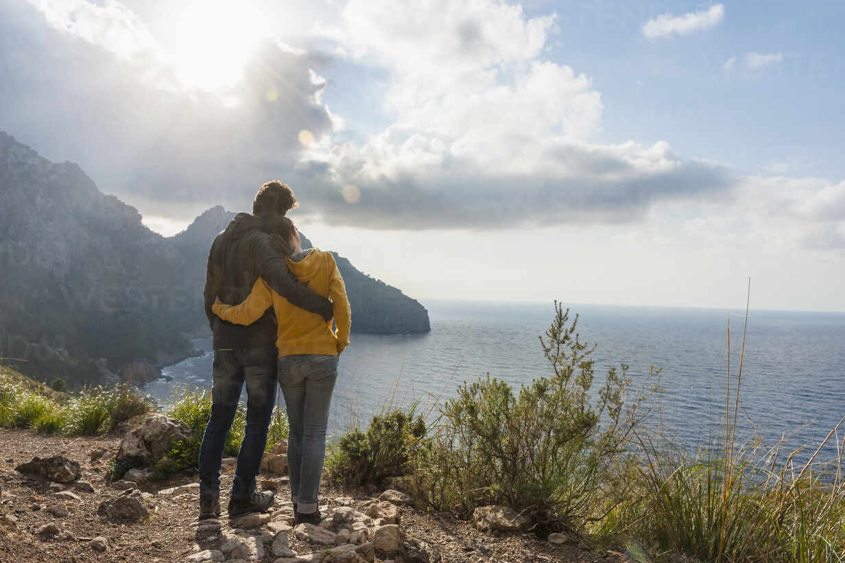 Back View Of Couple Standing Arm In Arm Looking To The Sea Mallorca Spain Stockphoto