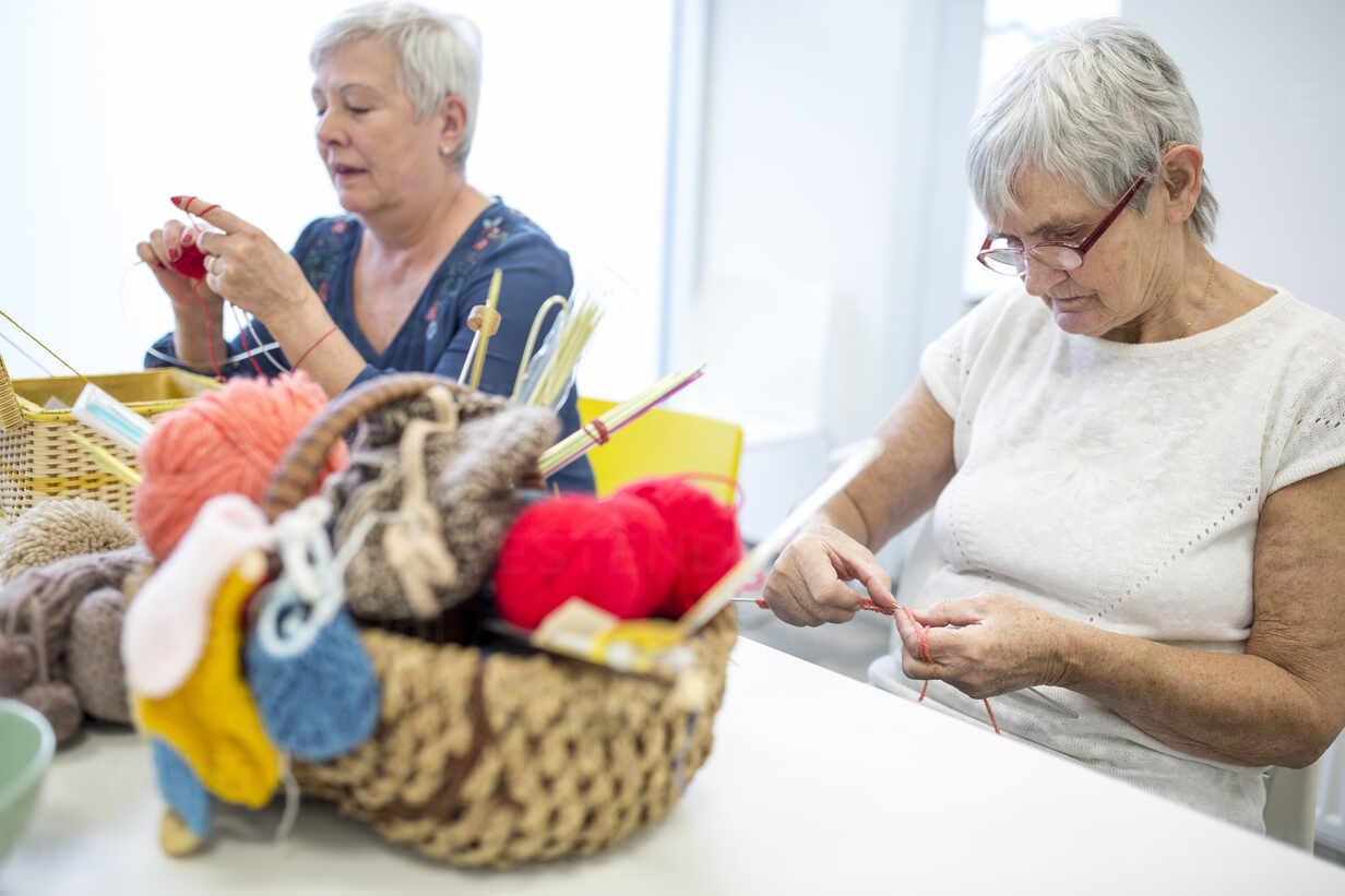 Senior Women Knitting Toghether In Needlework Group Of Retirement Home Stockfoto