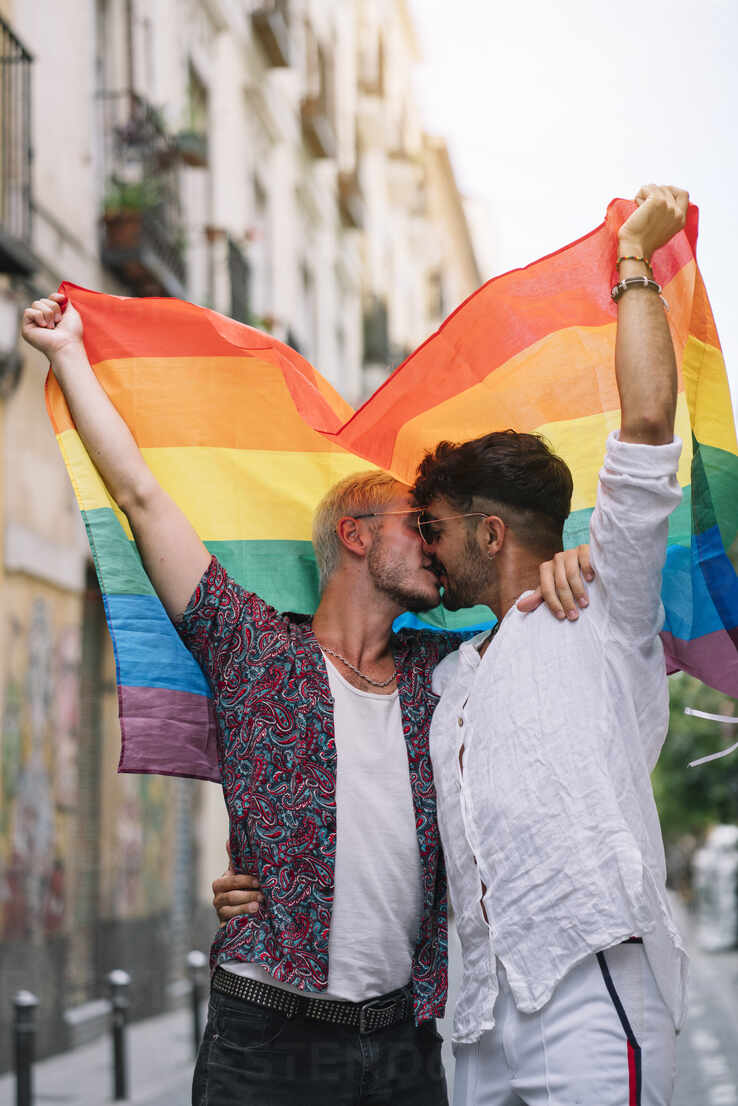 Couple Boys With Gay Pride Flag On The Street Of Madrid City Stockphoto