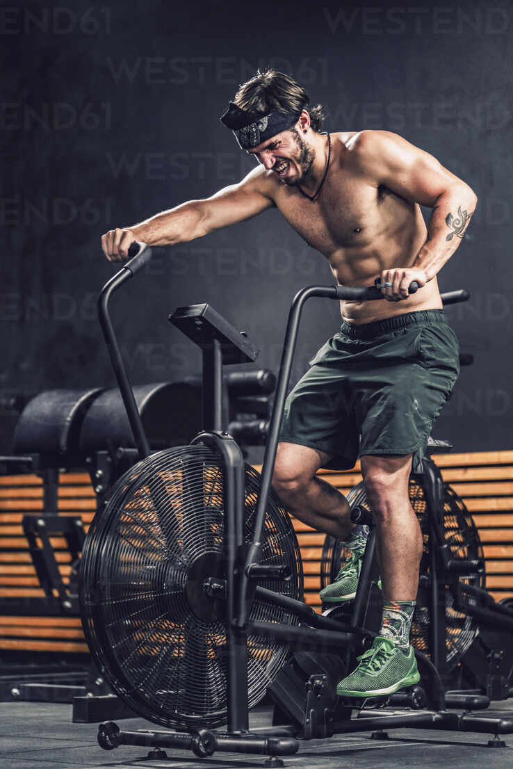Strong Man Training On Contemporary Exercise Bike In Sport Club Adsf Addictive Stock Creatives Westend61