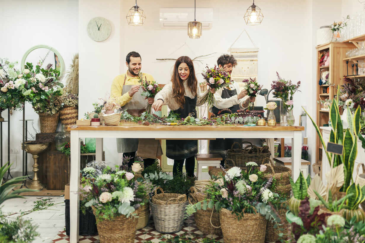 Florist Team Arranging Flowers And Plant While Standing At Flower Shop Mrrf Manu Reyes Westend61