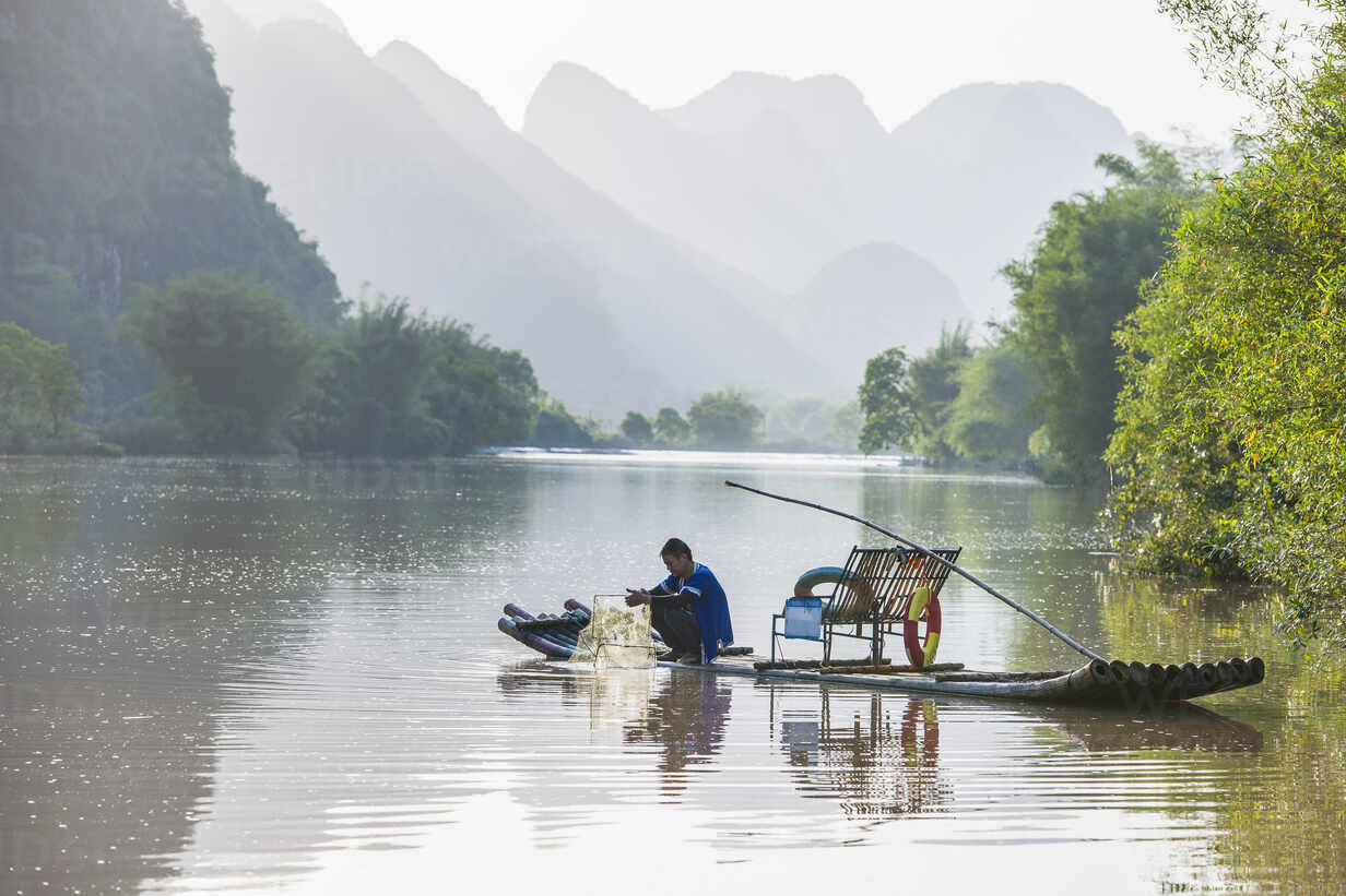 Fisherman On Traditional Raft On The Yulong River Close To Yangshuo Stockphoto